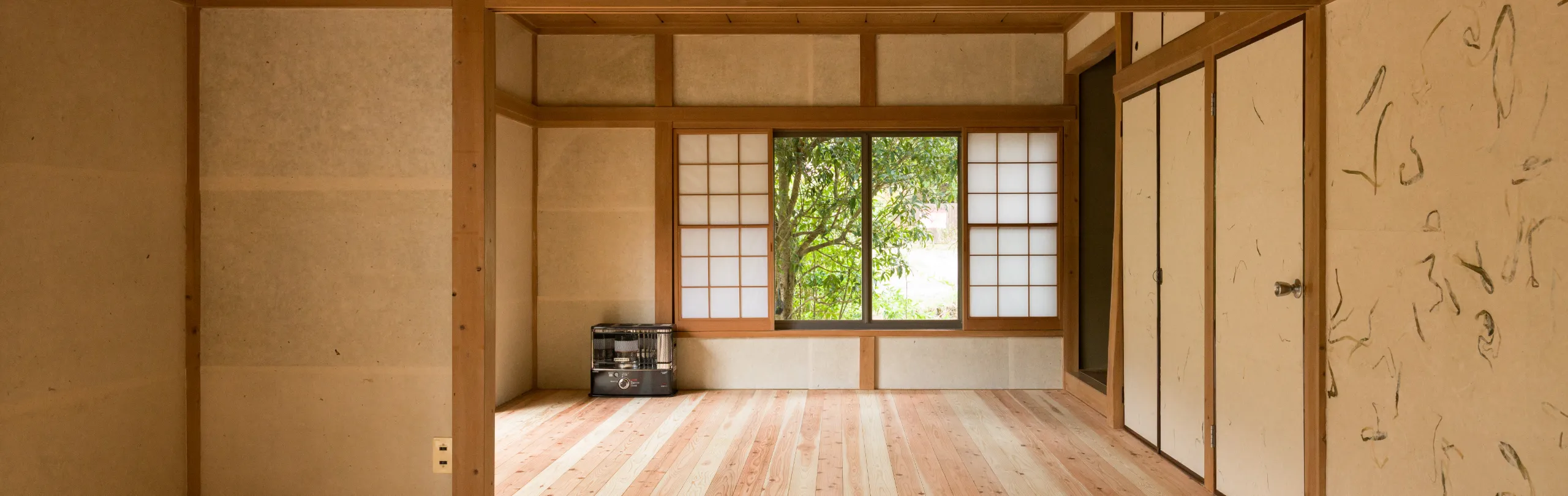 窓から木漏れ日が差し込んでいるシェアスペースの写真