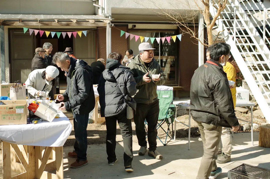 屋外のコミュニティイベントで食事や交流を楽しむ人々